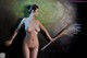A nude woman holding a broom in her hand.