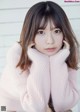 A woman in a pink sweater sitting on a chair.