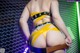 A woman in a yellow bikini with a tattoo on her back.